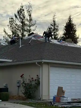 Crew in the middle of tearing off a garage roof