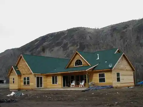 New cedar home with green shingles on a hillside