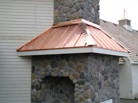 Copper cap on a river-rock chimney