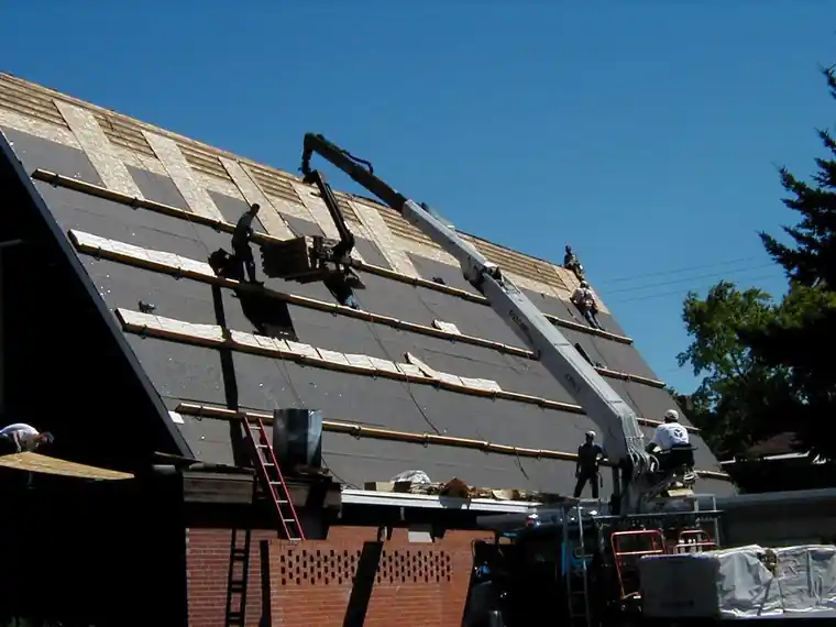 Boom loading shingles onto a stripped roof