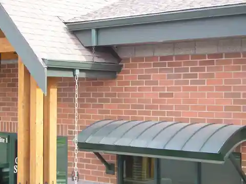 Curved green metal awning on a brick commercial building