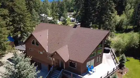 Drone view of a log home with its old brown roof