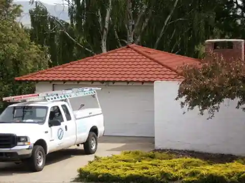 Red tile roof on a garage with a company pickup parked in front